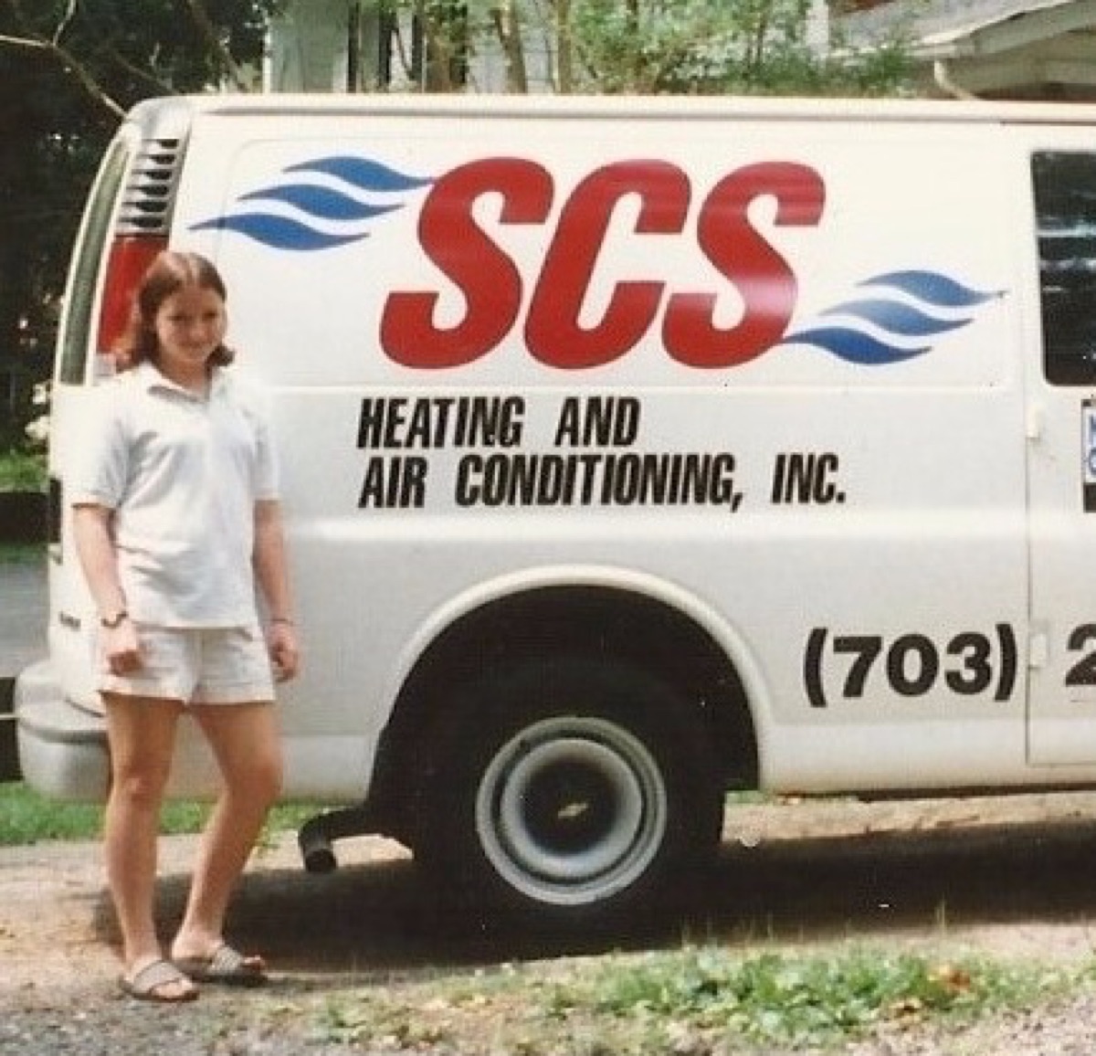 A Williams child beside the original SCS company van — family-owned since 1992